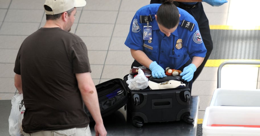 TSA agent inspecting a traveler's suitcase